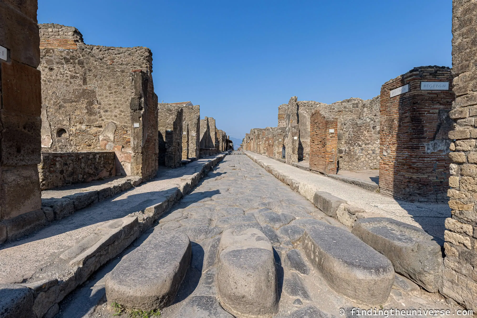 Ancient stone-paved street (cardo) in Pompeii lined with Roman columns